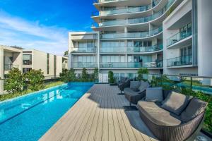 an apartment with a swimming pool and a building at Retro Modern with Pool near Westfield Doncaster in Doncaster