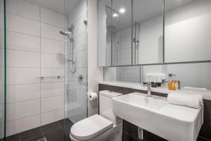 墨尔本Retro Modern with Pool near Westfield Doncaster的带水槽、马桶和淋浴的浴室