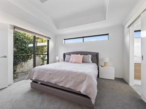 マンジュラにあるMariners Cove Luxury Canal Homeのベッドと大きな窓のある寝室