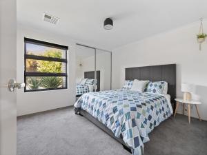 a bedroom with a bed and a window at Mariner's Cove Luxury Canal Home in Mandurah