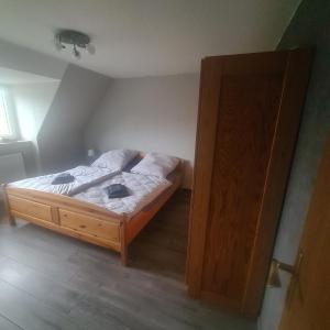 a bedroom with a bed and a wooden door at Haus Dithmarschen in Hemmingstedt