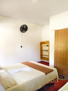 1 dormitorio con cama y armario en Chalé Ilha Verde-Cumuruxatiba, en Cumuruxatiba