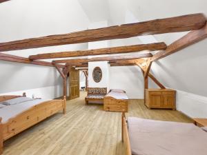 a bedroom with two beds and wooden beams at Marcelína in Mikulov v Krušných Horách