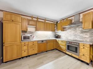 a kitchen with wooden cabinets and a brick wall at Marcelína in Mikulov v Krušných Horách