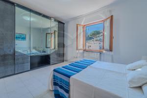 a bedroom with a bed and a glass shower at La Rondine su Seccheto - Goelba in Seccheto