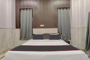 a large bed in a room with curtains at OYO Flagship Hotel Tri Palace in Kānpur
