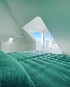 une chambre avec un lit vert avec une grande fenêtre dans l'établissement Just Sezimbra, à Sesimbra