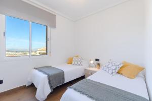 two beds in a white room with a window at The Big Chill by Fidalsa in Ciudad Quesada +26 photos