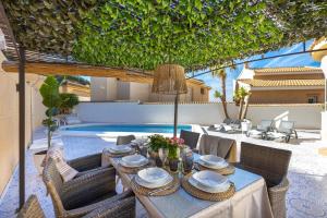 a table with plates and bowls on it next to a pool at The Big Chill by Fidalsa in Ciudad Quesada