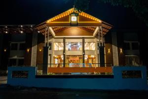 un edificio con un reloj encima por la noche en The Healing Hills Naturopathy and Wellness Center, en Coimbatore