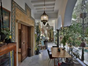 a hallway with a table and chairs and plants at Dar Souad in La Marsa