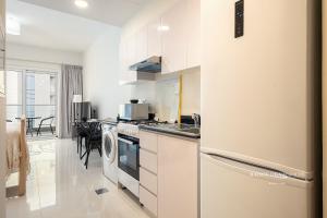een keuken met witte kasten en een fornuis met oven bij The Tranquil Spot in Damac Hills 2 in Dubai