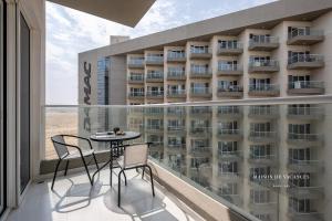 een balkon met een tafel en stoelen voor een hotel bij The Tranquil Spot in Damac Hills 2 in Dubai