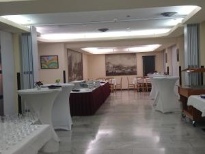 Hotel Ceresio في لوغانو: غرفة طعام مع طاولات بيضاء وكراسي بيضاء