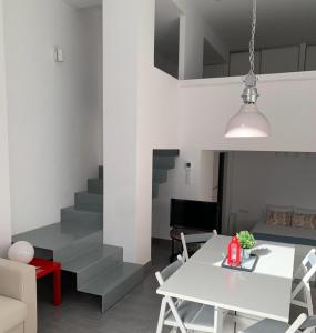 uma sala de estar com uma mesa branca e cadeiras em Loft Filipinas Vibes Coruña em La Coruña
