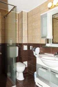 La salle de bains est pourvue de toilettes, d'un lavabo et d'un miroir. dans l'établissement Hotel Grand, à Eforie Nord