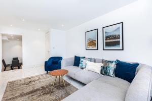 ein Wohnzimmer mit einem Sofa und einem Tisch in der Unterkunft Luxury Harley Street Apartments in London