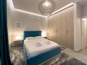 um quarto com uma cama azul num quarto em Anagnostopoulou Elegance 97sqm in Kolonaki em Atenas