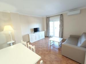 una sala de estar con un sofá y una mesa en Urbanización San bruno II en segunda planta., en Isla Canela