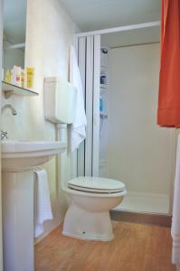 a bathroom with a toilet and a sink and a shower at Camping Village S'Ena Arrubia in Arborea