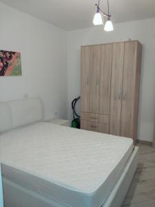 a bedroom with a bed and a wooden cabinet at Bella Costa in Dobra Voda