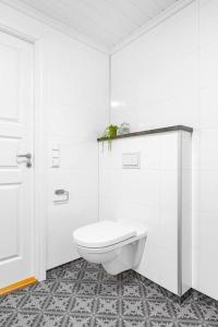 La salle de bains blanche est pourvue d'une douche et de toilettes. dans l'établissement Rorbu i Gilsvågen - 3 soverom - Båtutleie, à Austevoll