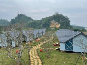 Homstay Mimosa Mộc Châu في موك تشاو: صف من البيوت في حديقة فيها اشجار
