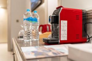 a red toaster sitting on a table with bottles of water at Malikia Resort Abu Dabbab in Abu Dabbab