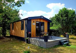 Tinyhaushotel - Campingpark Nabburg في نابورغ: منزل صغير مع شرفة في الفناء