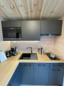 a kitchen with a sink and a microwave at Tinyhaushotel - Campingpark Nabburg in Nabburg