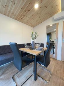 Tinyhaushotel - Campingpark Nabburg في نابورغ: غرفة طعام مع طاولة وكراسي خشبية