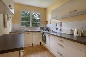 una cocina con electrodomésticos blancos y una ventana en 400m de la plage, Pointe St Gildas, maison pour 6, en Préfailles