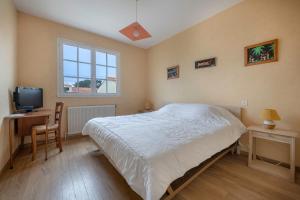 Un dormitorio con una cama grande y un televisor. en 400m de la plage, Pointe St Gildas, maison pour 6, en Préfailles 8 fotos más