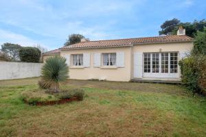una casa con una palmera en un patio en 400m de la plage, Pointe St Gildas, maison pour 6, en Préfailles
