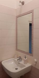 ein Badezimmer mit einem weißen Waschbecken und einem Spiegel in der Unterkunft A casa di Rebecca in 