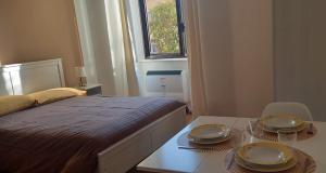 ein Schlafzimmer mit einem Bett und einem Tisch mit Tellern darauf in der Unterkunft A casa di Rebecca in 