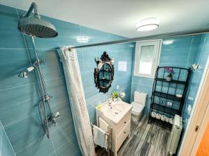 een blauwe badkamer met een wastafel en een douche bij El Puente del Pilar ComoTuCasa in Zaragoza +28 foto's