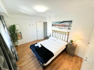 een slaapkamer met een groot bed en een houten vloer bij El Puente del Pilar ComoTuCasa in Zaragoza