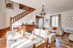 ein Wohnzimmer mit einem Tisch und einer Treppe in der Unterkunft Parenthese familiale entre plage et golf in Pléneuf-Val-André