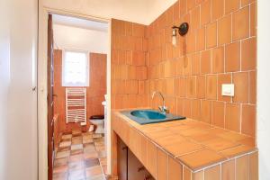 an orange tiled bathroom with a sink and a toilet at Parenthèse familiale entre plages et golf in Pléneuf-Val-André +17 photos
