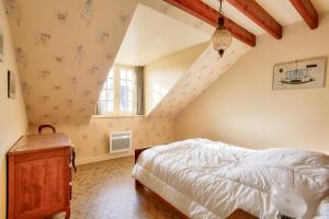 ein Schlafzimmer im Dachgeschoss mit einem Bett und einer Treppe in der Unterkunft Parenthese familiale entre plage et golf in Pléneuf-Val-André