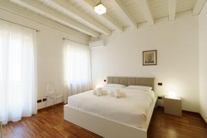 a white bedroom with a white bed with two pillows at Residenza Marconi - Domus Verona in Verona