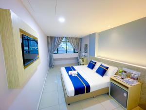 StarQ Hotel Bukit Bintang في كوالالمبور: غرفه فندقيه سرير وتلفزيون