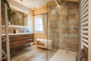 y baño con ducha y cabina de ducha acristalada. en Chalet Jochwand Bad Goisern, en Bad Goisern
