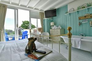 un dormitorio con una cama con un osito de peluche sentado en ella en Lulworth Cove Inn, en Lulworth Cove
