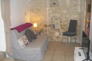 a living room with a couch and a chair at La Bergerie Lou Mas Li Pitchoun in Gordes