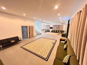 ein Wohnzimmer mit einem Sofa und einem Teppich in der Unterkunft 4 Bedrooms villa for rent in Al Ḩamīdīyah