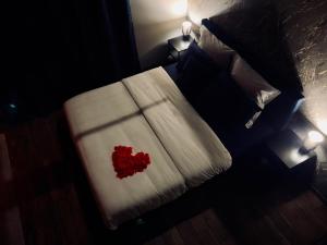a bedroom with a bed with a red heart on it at Les secrets d'Eros - DAX in Dax