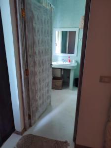 a bathroom with a sink and a mirror at GIORGIA HOUSE WATAMU BEACH in Watamu