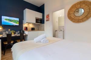 1 dormitorio con 1 cama blanca y cocina en Lille Center - Nice studio, en Lille